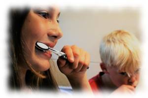 Bild mit Zähne putzender Frau und Kind zum Thema Zahnpflege für empfindliche Zähne